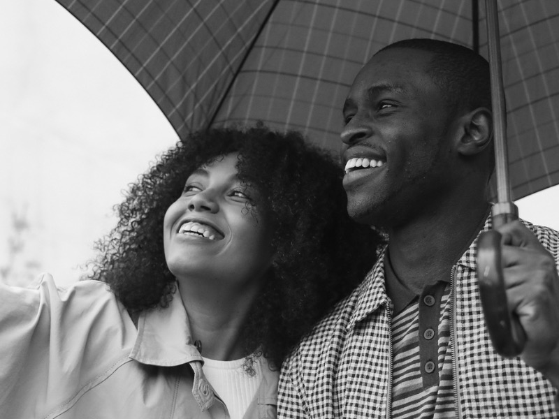 man and women under umbrella in black and white photo